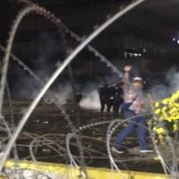 geger-wanita-bergamis-hitam-berjalan-mendekati-kerumunan-aparat