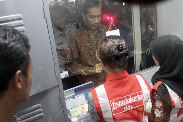 Pakai Batik, Jokowi Bergelantungan di Busway