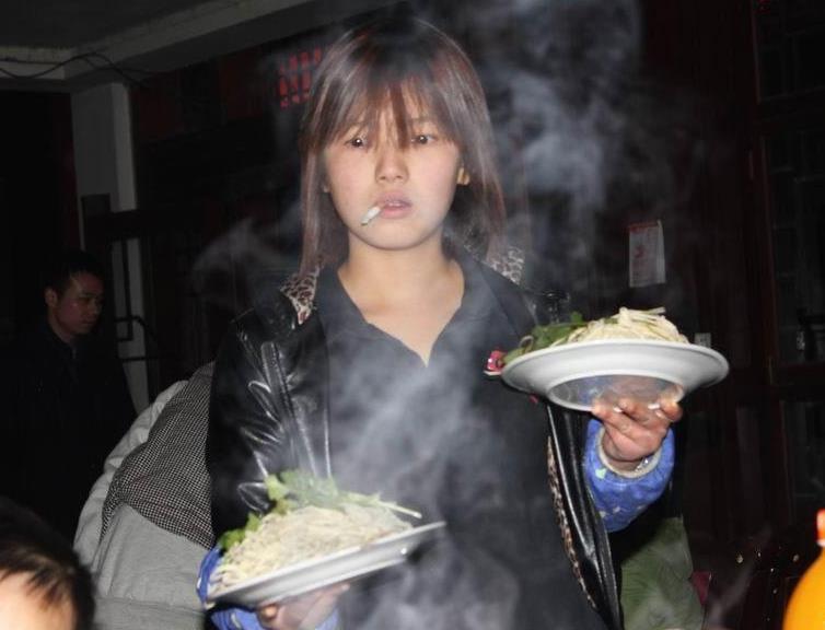 Pelayan resto cantik, tatapan tajam, rokok dibibir, kedua tangan membawa makanan