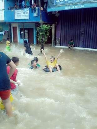 Anak-anak di Kampung Pulo Jadikan Lokasi Banjir Seperti 'Water Boom'