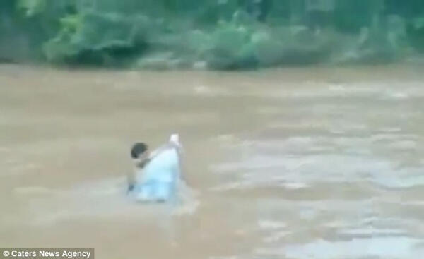 Orang ini Mengantarkan Anaknya ke Sekolah dengan Menyeberangi Banjir
