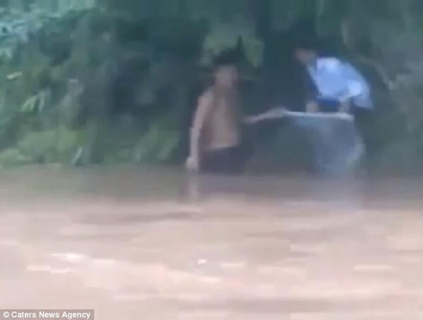 Orang ini Mengantarkan Anaknya ke Sekolah dengan Menyeberangi Banjir