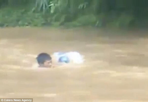 Orang ini Mengantarkan Anaknya ke Sekolah dengan Menyeberangi Banjir