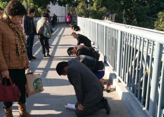 Lima Karyawan Dihukum Bersimpuh di Jembatan