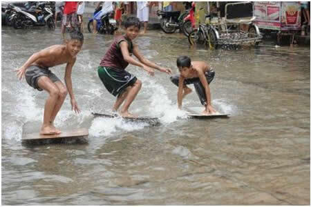 Hal Unik Anak-Anak Nekat Surfing di Tengah Derasnya arus Banjir