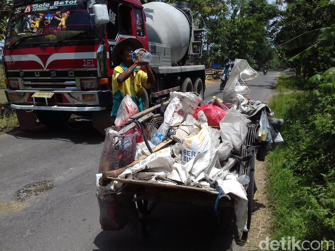 Begini Aksi Mbah Sadiyo Tambal Jalan Berlubang Sendirian