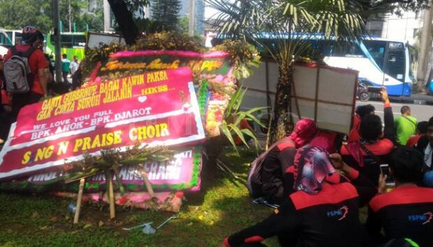 Hujan, Buruh Gunakan Karangan Bunga Untuk Ahok Jadi Pelindung