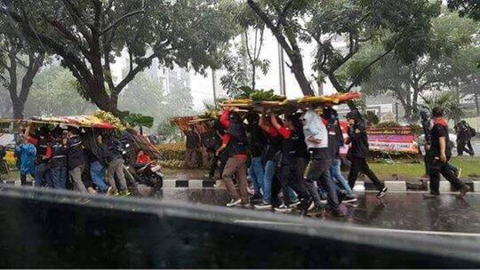 Hujan, Buruh Gunakan Karangan Bunga Untuk Ahok Jadi Pelindung