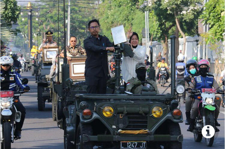 SURABAYA, KOMPAS.com - Wali Kota Surabaya Tri Rismaharini mengarak piagam penghargaan