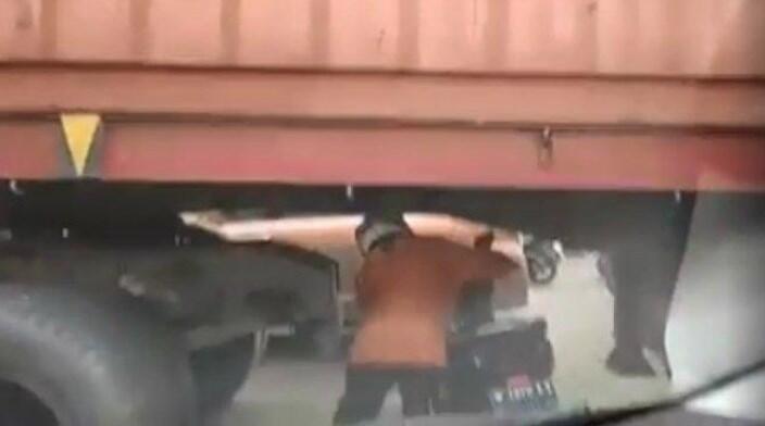 Viral! Gak Tahan Macet, Emak-emak Ini Nekat Dorong Motornya Lewati Kolong Kontainer