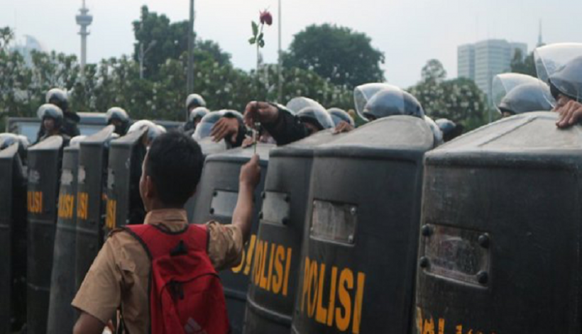 Pelajar Berikan Setangkai Bunga ke Polisi