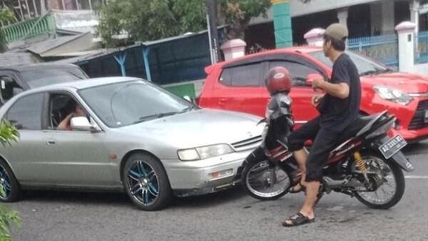 Seorang Pengendara Duduk Santuy di Atas Motornya di Tengah Jalan! Sedang Apa Dia Ya?