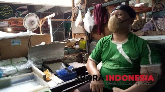 Gokil! Pedagang Ini Pakai Masker Corona dari Batok Kelapa