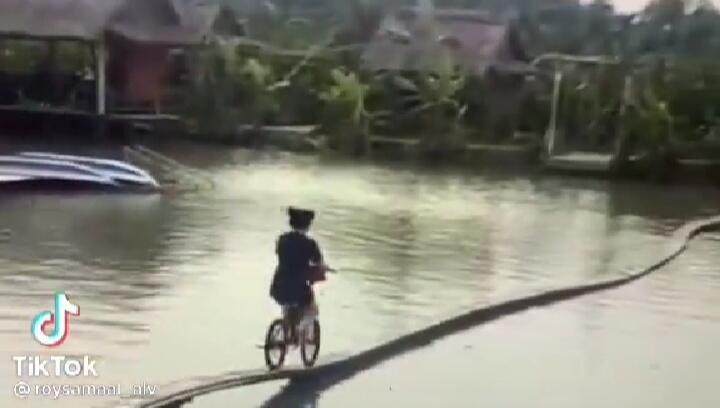 Menegangkan, Seorang Wanita Seberangi Jembatan Kecil di Tengah Sungai Gunakan Sepeda!