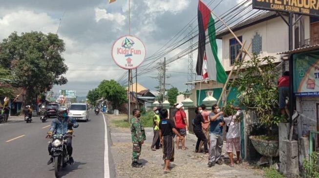 Viral Potret Warga Turunkan Bendera Palestina yang Berkibar di Pinggir Jalan