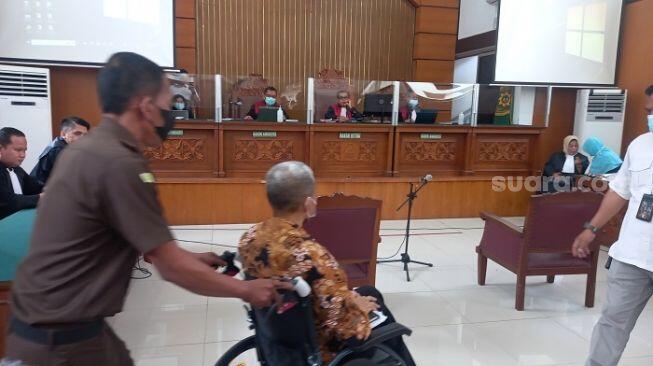 M Kece Kini Dibawa ke Sidang Pakai Kursi Roda dengan Kondisi Tangan Terborgol